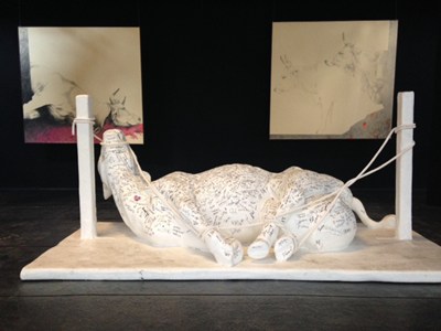 scultura di una vacca legata e sofferente