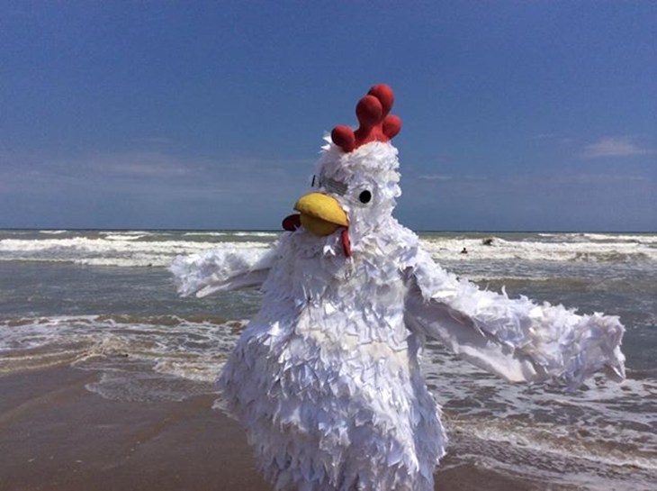 persona con costume da pollo, in posa al mare